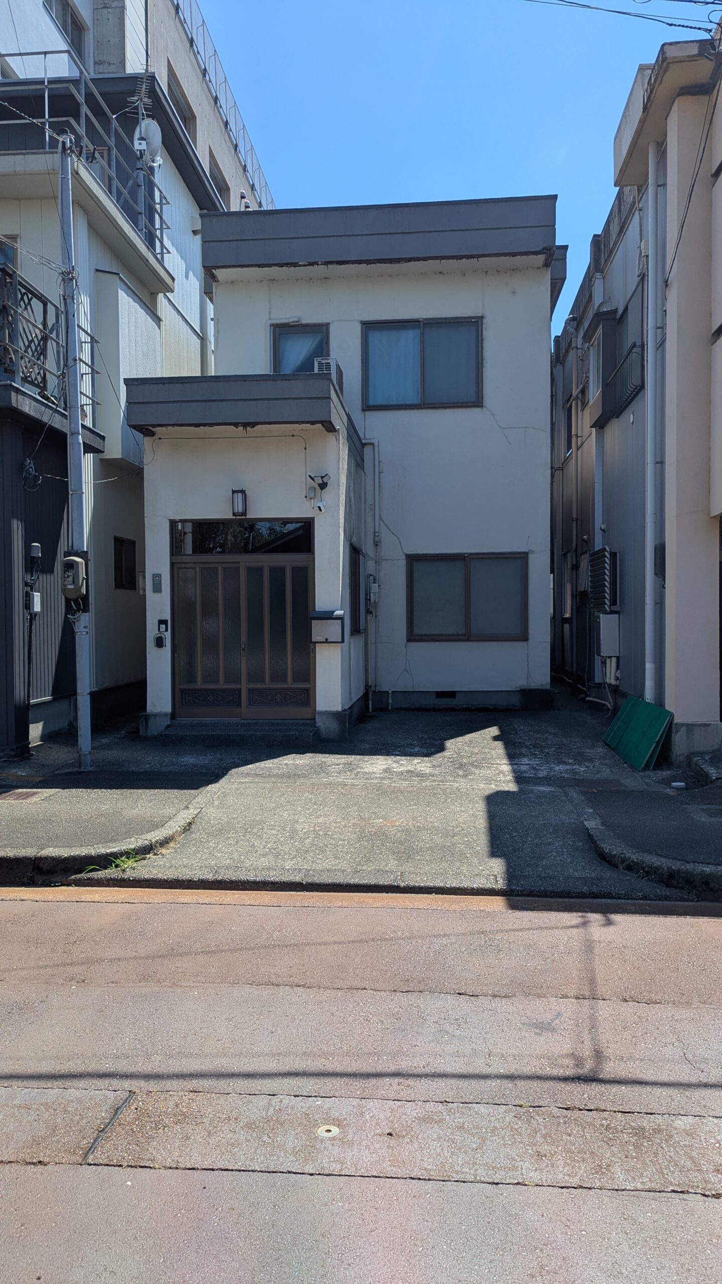 玄関と駐車スペースが分かるミンナイン坂之上の外観